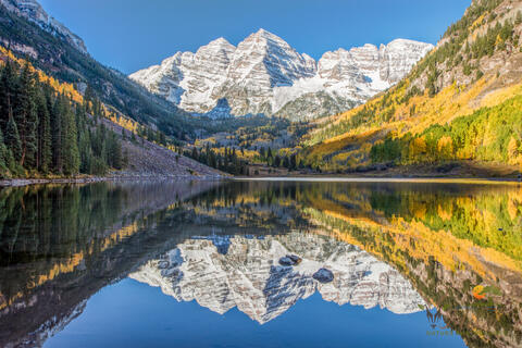 Maroon bells reflected into maroon lake with golden aspens