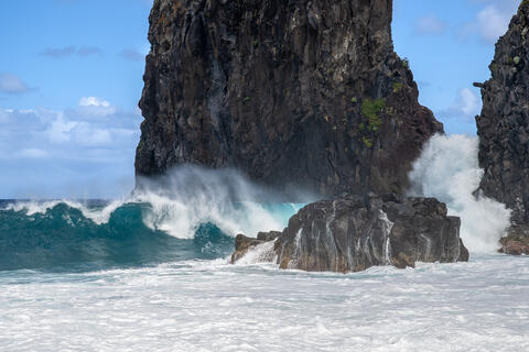 Pounding waves are seen crashing into the rock formations at Miradouro da Ribeira da Janela  on the island of madeira Portugal. 