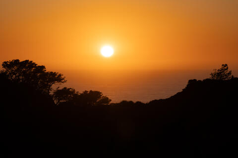 colorful, orange Sunset over the Pacific Ocean as seen from Torrey Pines state natural reserve.