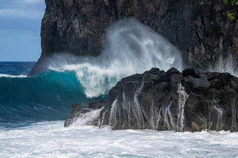 Pounding waves are seen crashing into the rock formations at Miradouro da Ribeira da Janela  on the island of madeira Portugal. 