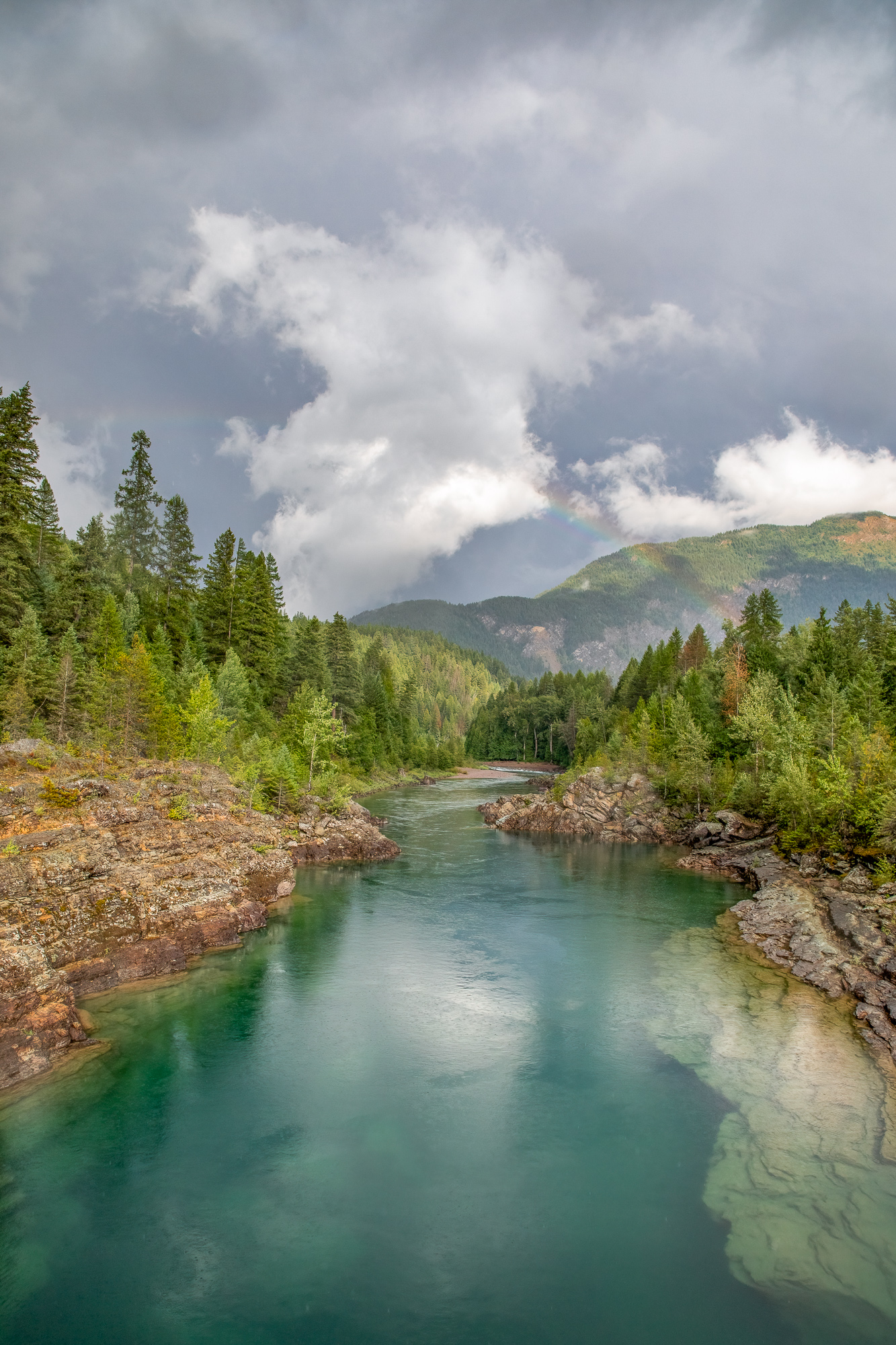 Rainbow, Clouds and Flathead River A rainbow forms as a storm clears over the Middle Fork of the Flathead River in Montana, USA, just outside of Glacier NAtional Park